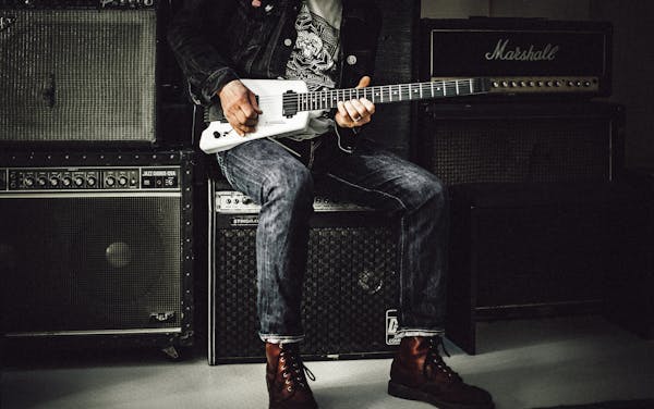 Playing guitar while sitting on amplifier